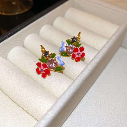 Floral jewelry set with vibrant hues, faux pearls, and CZ accents. Gold-plated vintage charm inspired by poppies and lyrical prose.