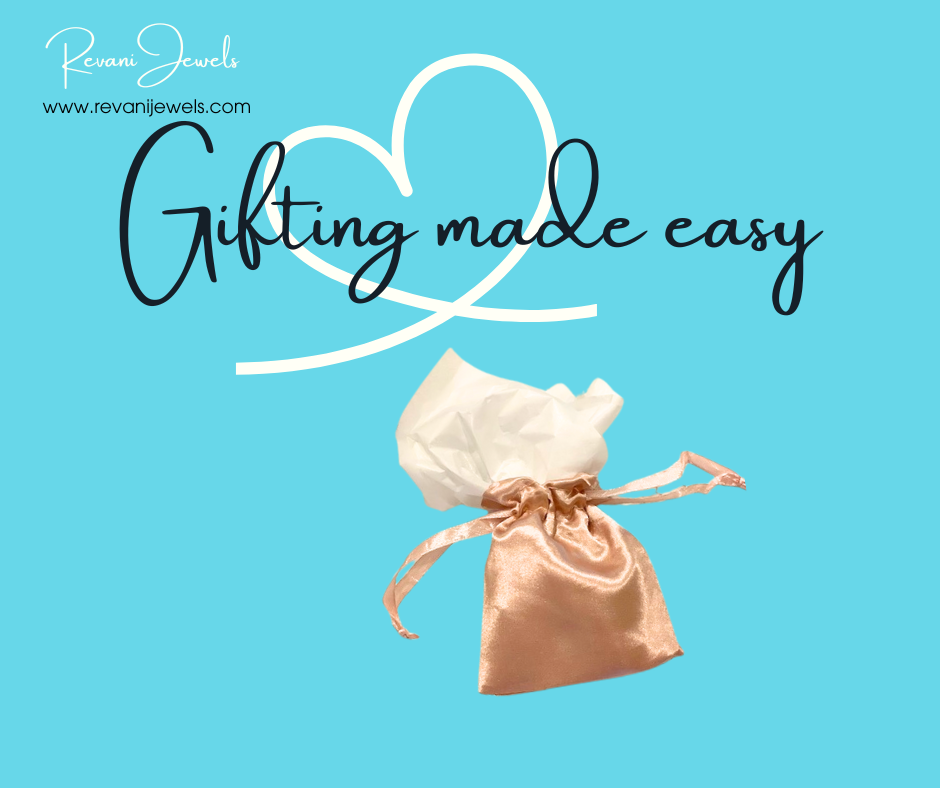 Small pink satin bag with a white heart-shaped pillow on a blue background, featuring 'Revan Jewels' branding.