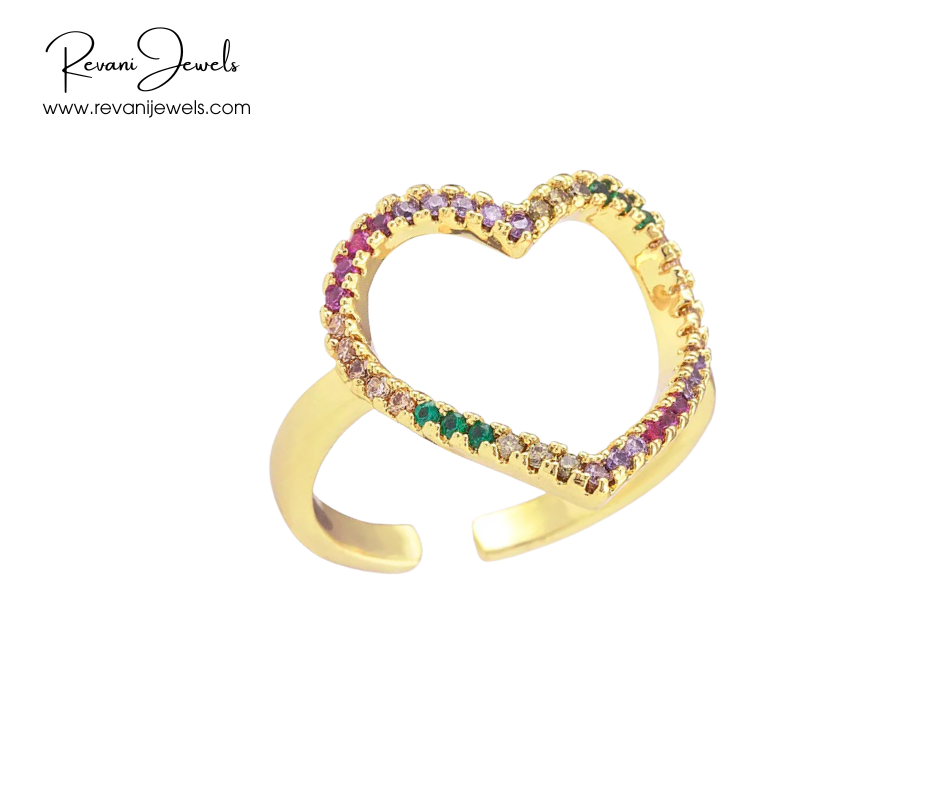 Gold heart-shaped ring with colorful gemstones on a white background, branded 'Revani Jewels'.