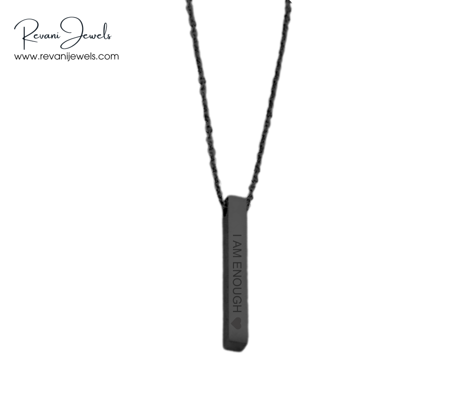 Black necklace with a pendant that says 'I AM ENOUGH' on a white background, branded by Revani Jewels.