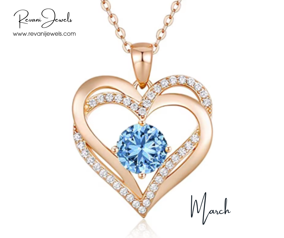 Heart-shaped gold pendant with blue gemstone and diamonds, branded 'Revani Jewels', on a white background.