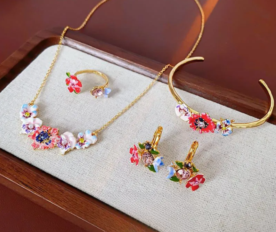 Floral jewelry set with vibrant hues, faux pearls, and CZ accents. Gold-plated vintage charm inspired by poppies and lyrical prose.