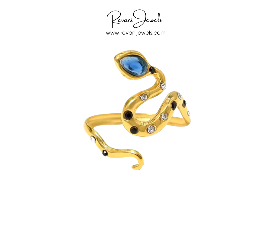 Gold ring with blue gemstone and black stones on a white background, branded 'Revani Jewels'.