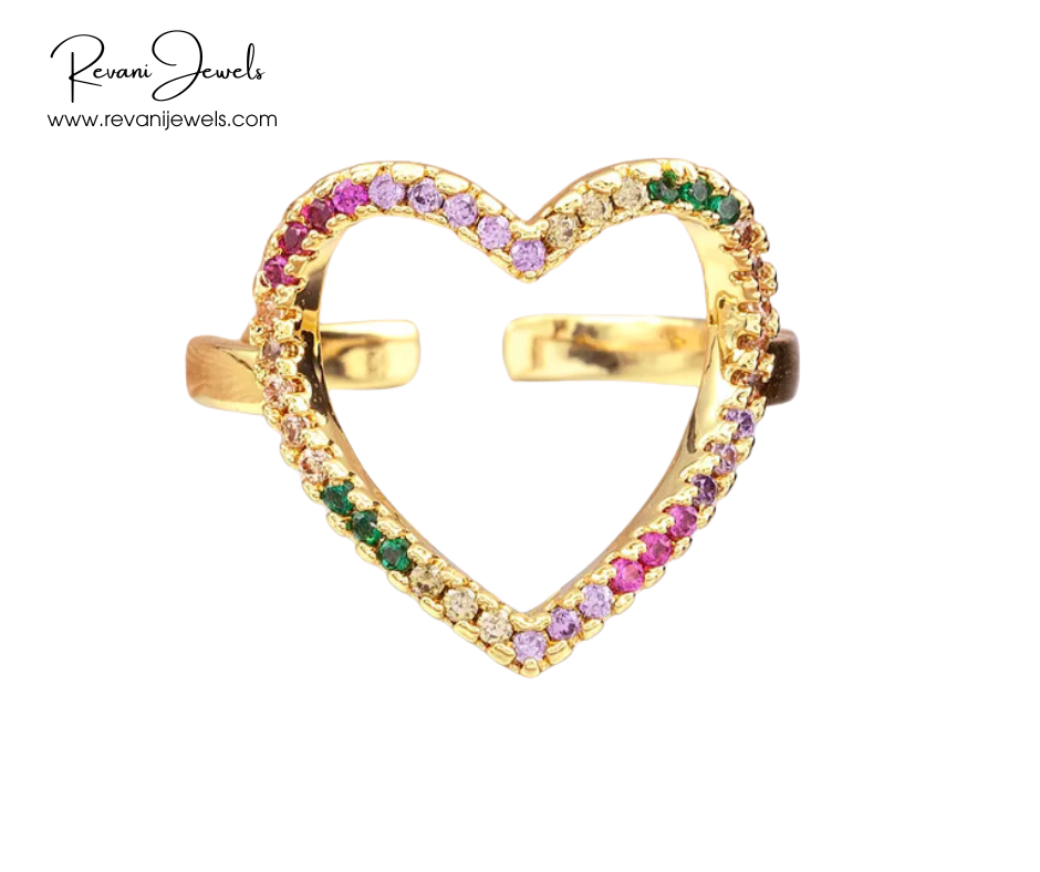 Gold heart-shaped ring with colorful gemstones on a white background, branded 'Revani Jewels'.