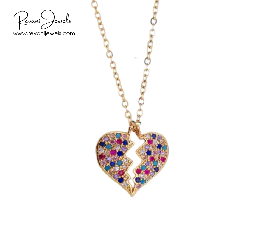 Gold necklace with a broken heart-shaped pendant featuring colorful stones on a white background, branded 'Revani Jewels'.