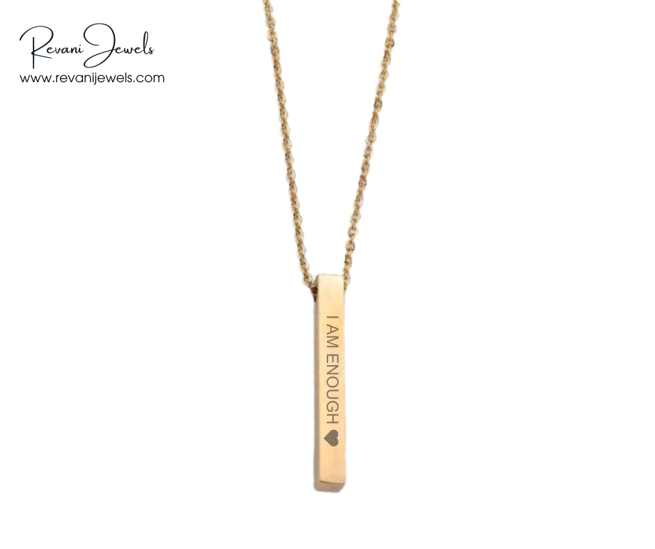 Gold necklace with a pendant that reads 'I AM ENOUGH' on a white background, branded with Revani Jewels.