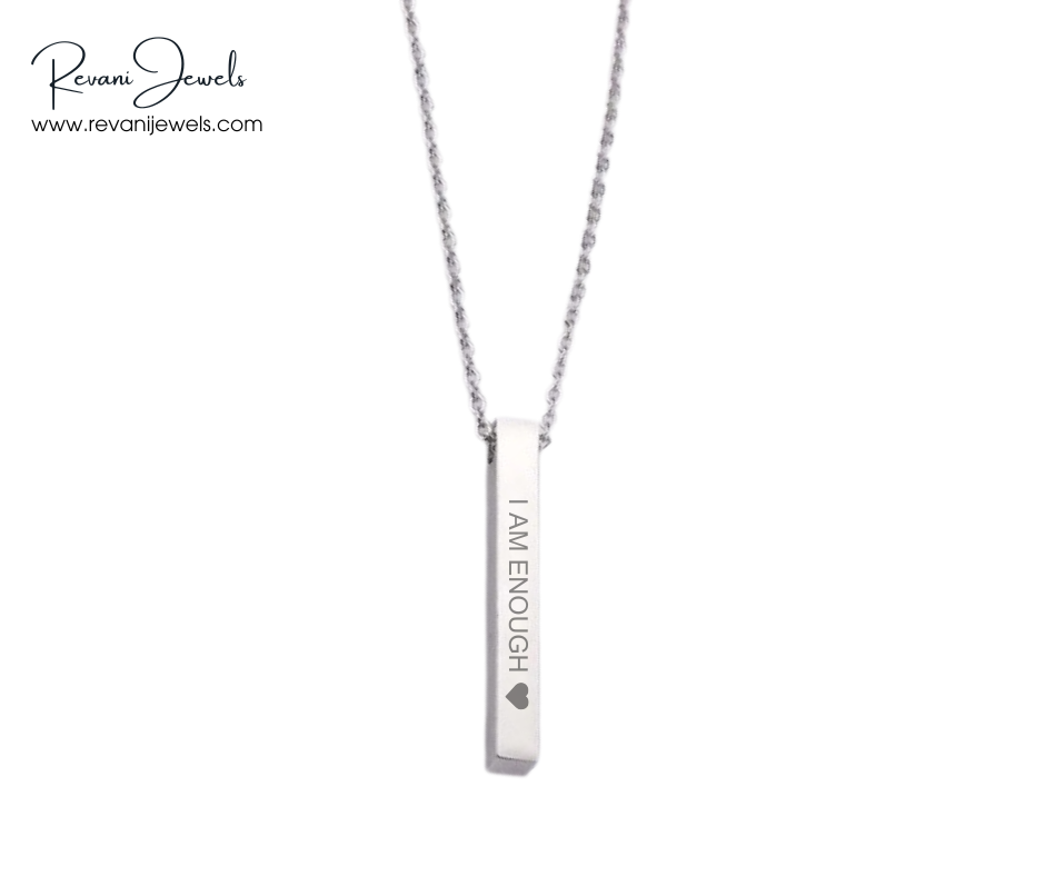 Necklace with a pendant that says 'I AM ENOUGH' on a white background, branded by Revani Jewels.