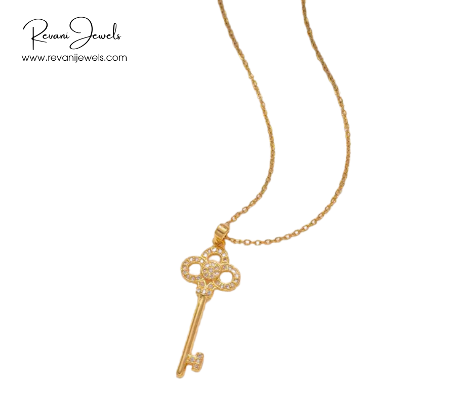 Gold key-shaped pendant necklace on a white background with Revani Jewels branding.