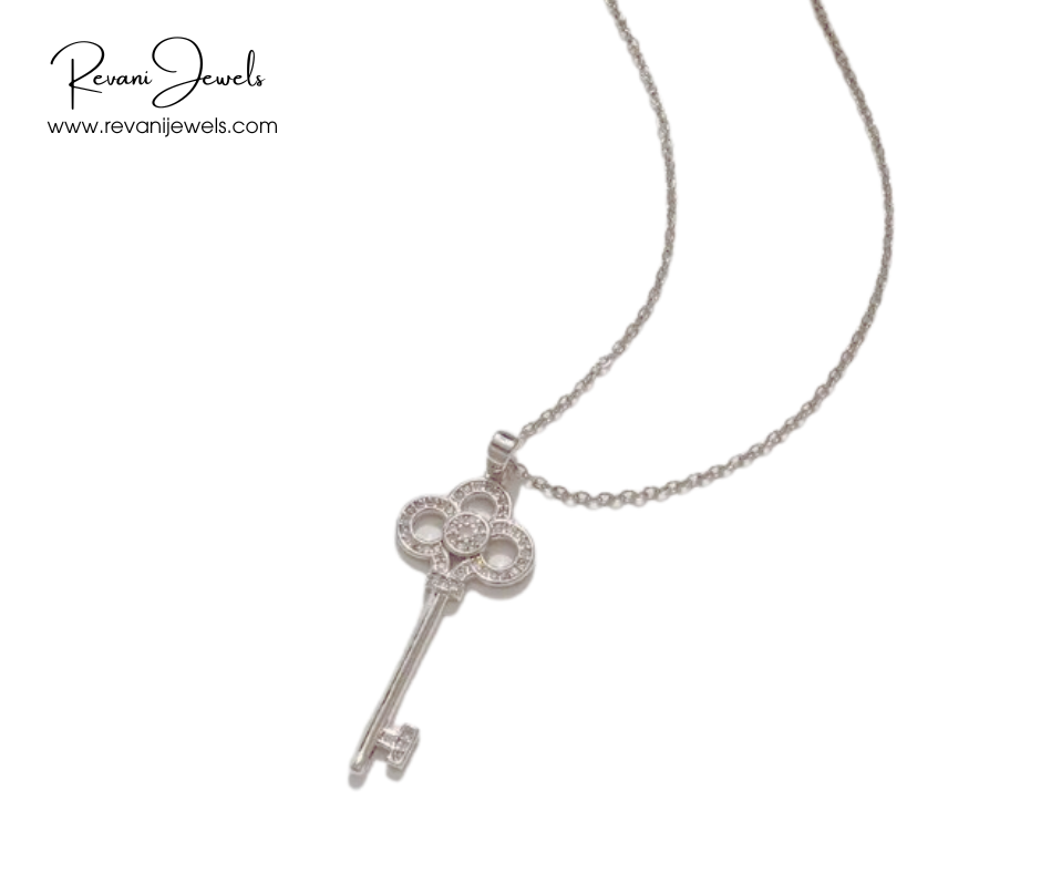 Silver key-shaped pendant on a chain with Revani Jewels branding.