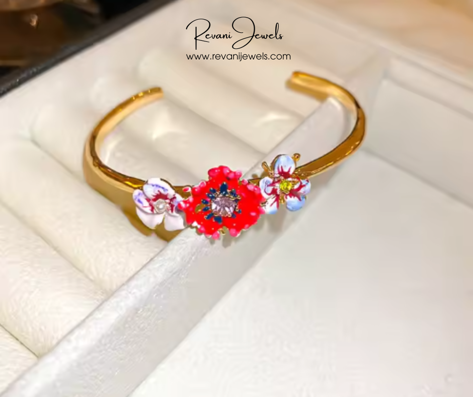 Gold bracelet with floral designs on a white surface, branded 'Revani Jewels'.