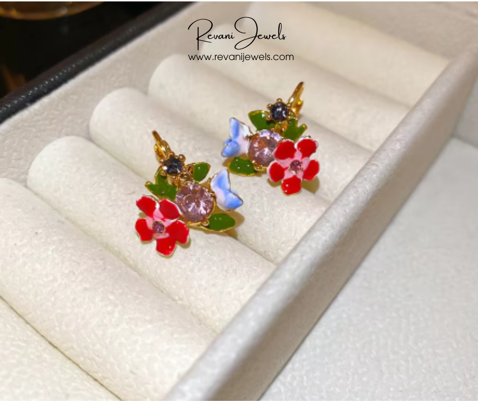 Colorful floral earrings in a jewelry box with Revani Jewels branding.