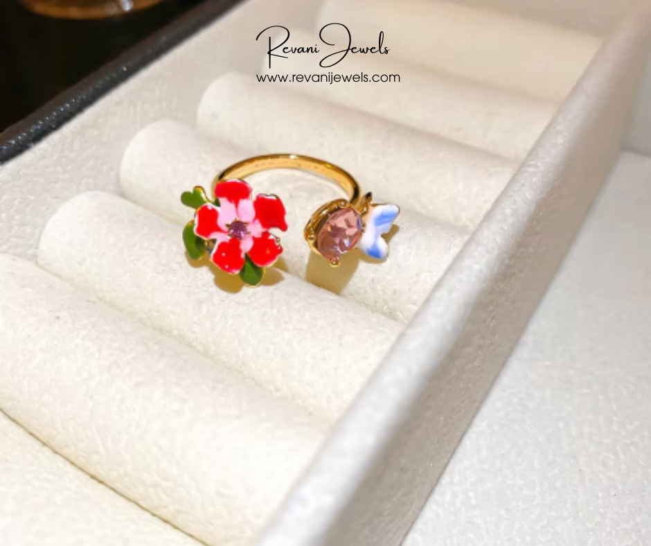 Gold ring with floral design on a white cushion, branded 'Revani Jewels'.