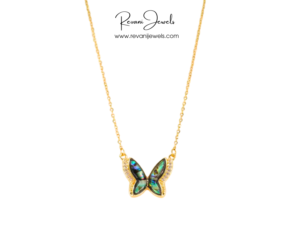 Butterfly-shaped pendant on a gold chain with Revani Jewels branding.