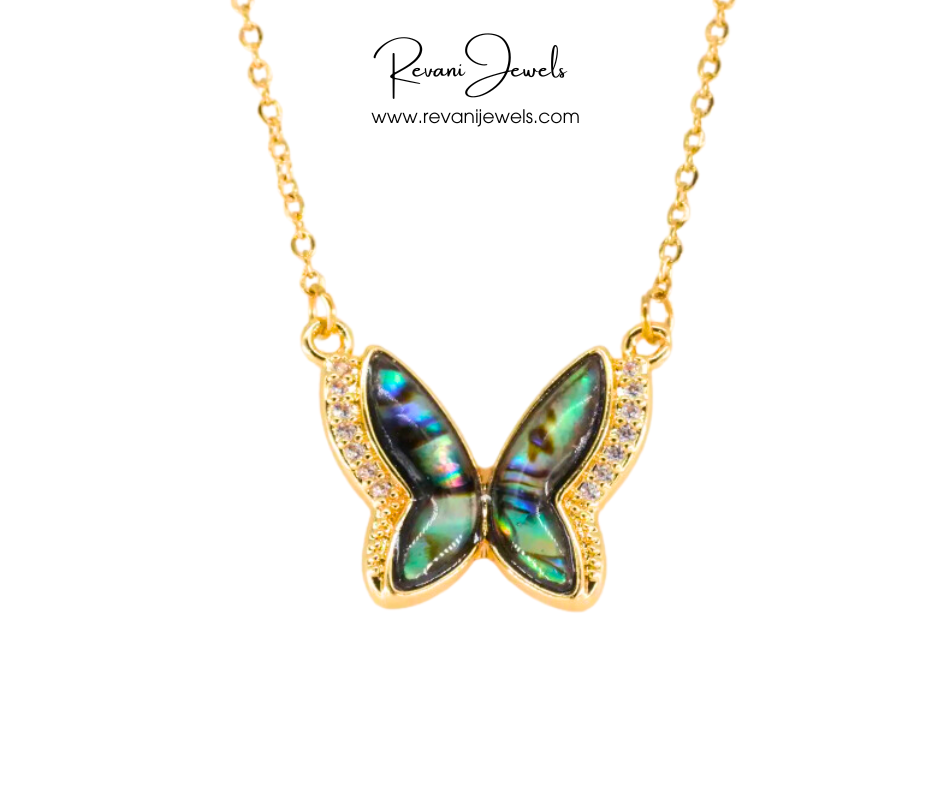 Butterfly-shaped pendant necklace with gold chain on a white background, branded 'Revani Jewels'.