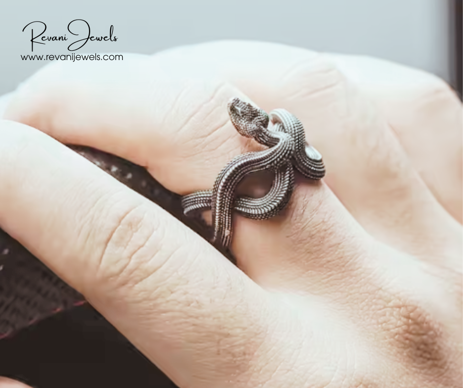 Silver snake-shaped ring on a finger with Revani Jewels branding.