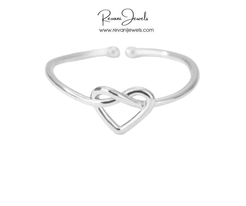 Silver heart-shaped bangle on a white background with Revani Jewels branding.